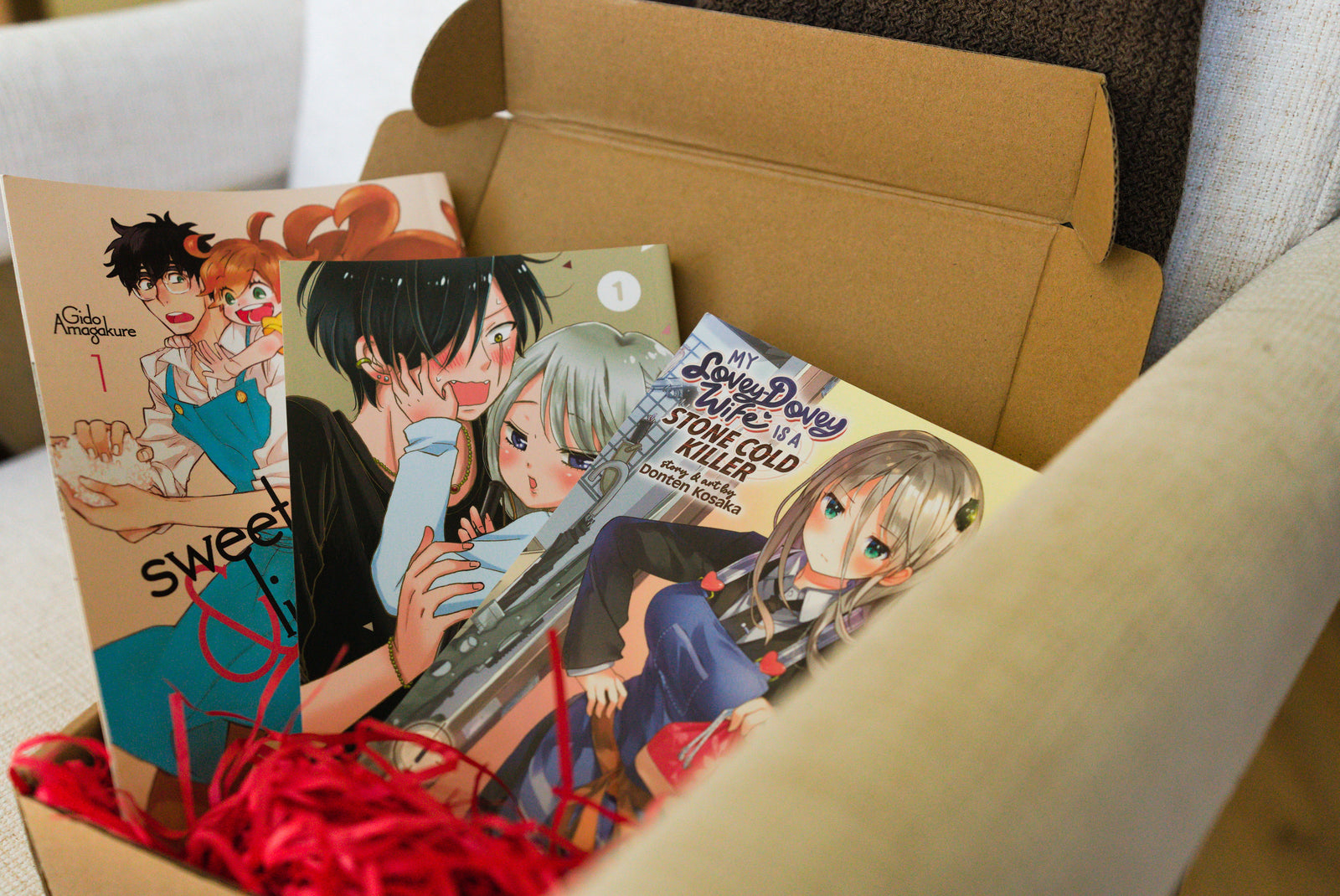 An opened Honsama box with three manga volumes